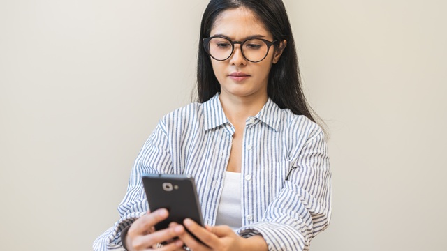 Presbyopia, Hyperopia middle aged asian woman holding eyeglasses problem with vision blurred ,trying to read text message from smart mobile phone screen, eye disease of old, eyesight farsightedness.